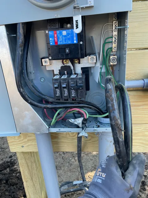 Meter-main disconnect enclosure open with service conductors being wired